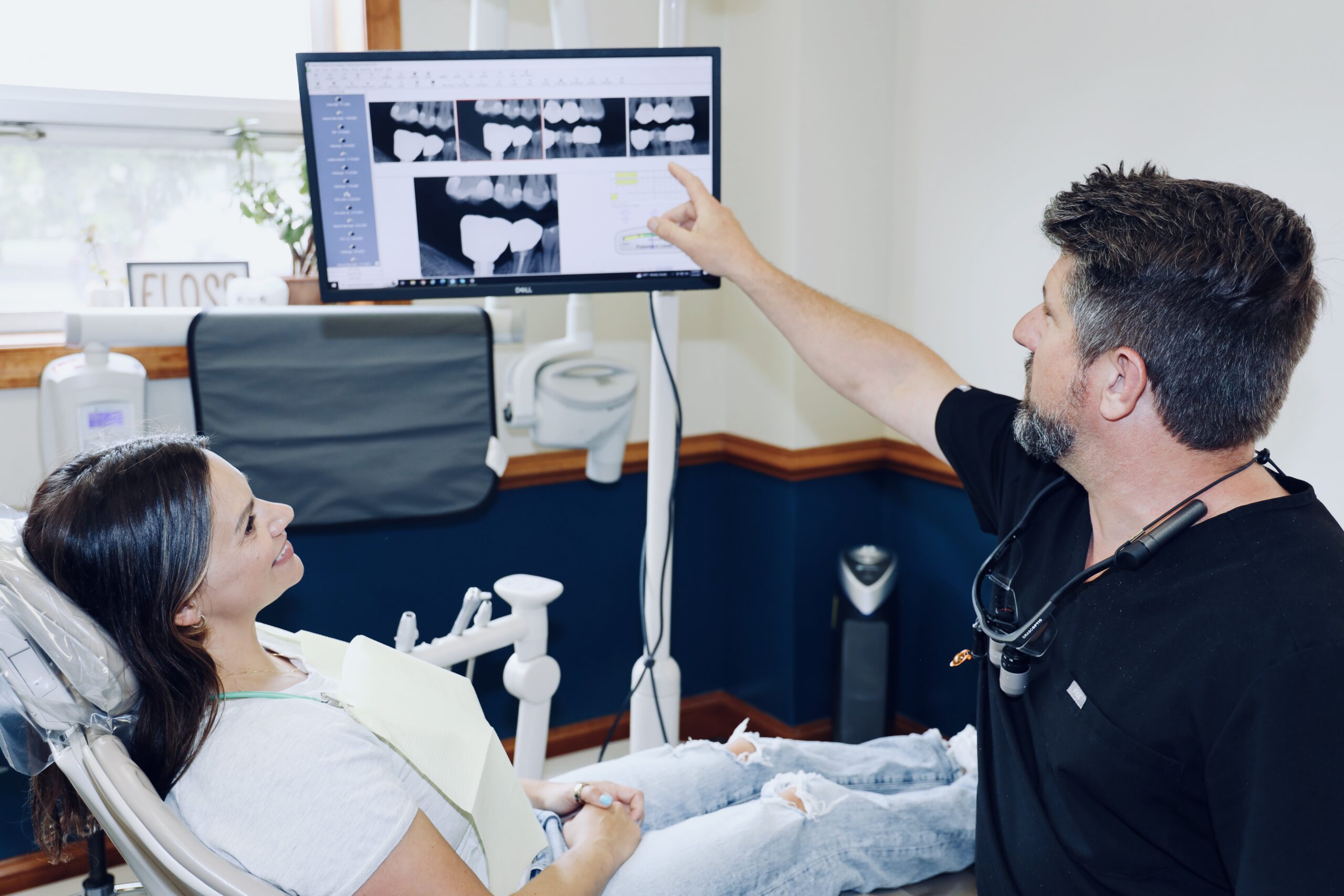 A doctor showing a patient x-rays on the computer screen.