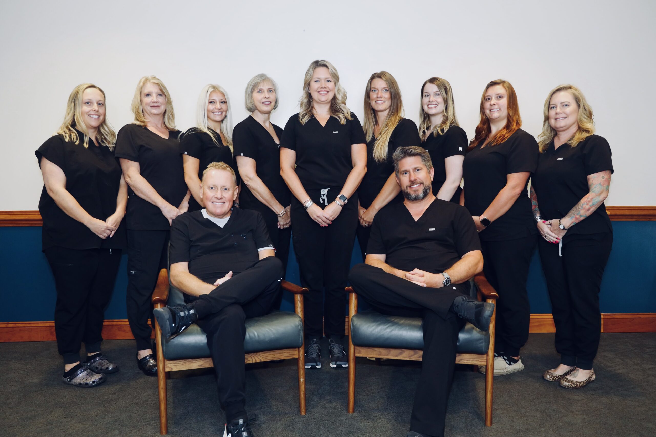 A group of people in black shirts and chairs.